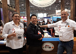 店主が展示会でチーズ会社の方と笑顔で映っている画像