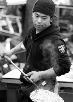 店主がピザを焼いている画像